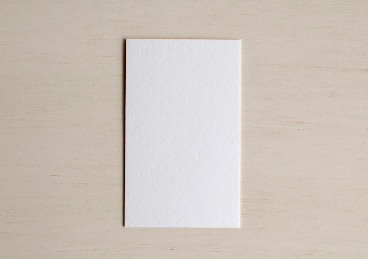 （写真24）特Aクッション 0.6。色名：白。両面印刷にも向くしっかりとした約0.6mmの厚みがあり嵩高でコシのある用紙で、大きめの図柄でも両面印刷可能。コースター用の紙としても使われている。表面的には硬めの紙だが、密度が低いため、しっかりとした凹みが出る。