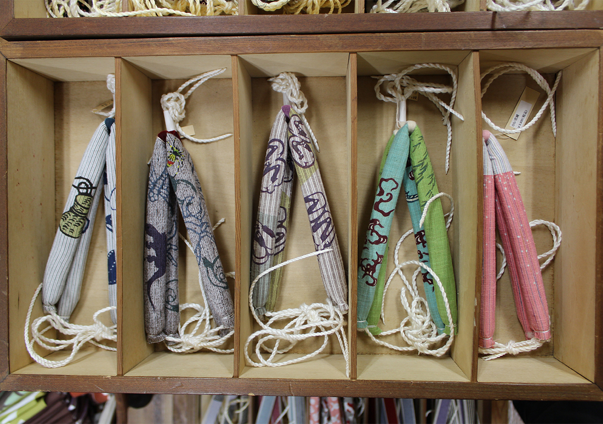 （図3）小倉充子さんのデザインによる下駄や花緒の展示。（図2）の左は「蕎麦」、右は「蛸」がモチーフになっている。 | 木版画調の型染図案を配したショップカード＆名刺 - 生田信一（ファー・インク） | 活版印刷研究所