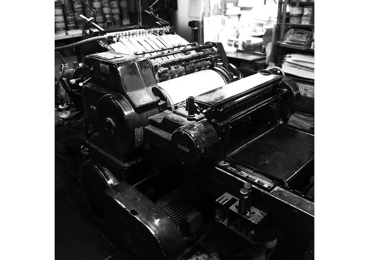 （写真1）活版印刷機、ハイデルベルグ社のシリンダー式印刷機（KSB）。B3まで印刷できます。平圧式のプラテン機と違い、一定の圧力をかけられるため、ムラのない仕上り。また、大きな機械なので、版面の大きな印刷物も、力強いプレスが可能。 | 宮田印刷が手がける「 LETTERPRESS BOOK COVER 」 - 生田信一（ファーインク） | 活版印刷研究所