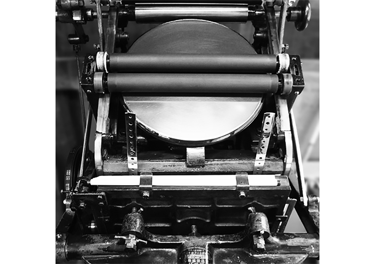 （写真2）岩橋栄進堂 半自動手フート機。半自動のプラテン式印刷機。A5サイズまで印刷できる。給紙が手動なので、厚みのあるもの、四角くないものでも印刷できます。 | 宮田印刷が手がける「 LETTERPRESS BOOK COVER 」 - 生田信一（ファーインク） | 活版印刷研究所